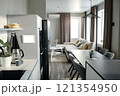 Roomy studio apartment illumed with sunrays through huge rectangular windows 121354950