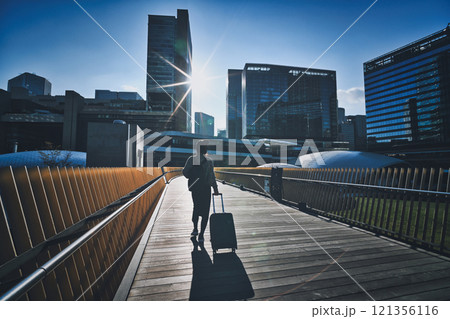 キャリーケースを持った女性旅行者の後ろ姿 121356116