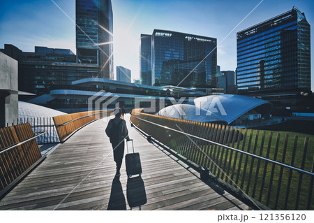 キャリーケースを持った女性旅行者の後ろ姿 キャリーケースを持った女性旅行者の後ろ姿 121356120