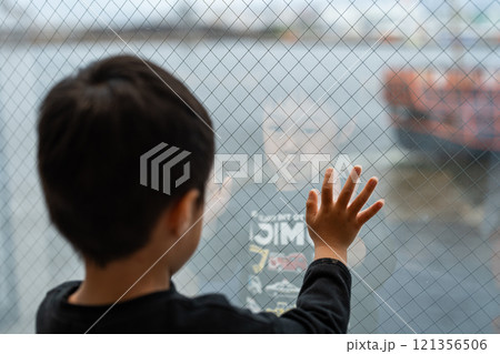 ガラス窓から外を眺める男の子 121356506