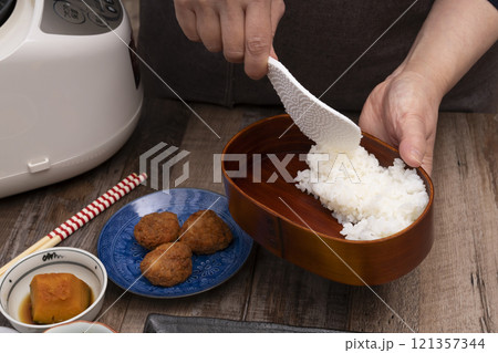 弁当箱にご飯やおかずを詰める手元 弁当箱にご飯やおかずを詰める手元 121357344