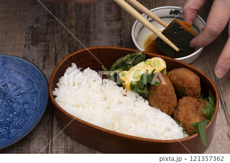 弁当箱にご飯やおかずを詰める手元 弁当箱にご飯やおかずを詰める手元 121357362