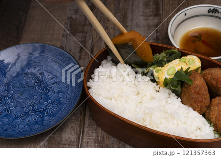 弁当箱にご飯やおかずを詰める手元 121357363