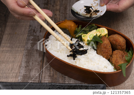 弁当箱にご飯やおかずを詰める手元 弁当箱にご飯やおかずを詰める手元 121357365