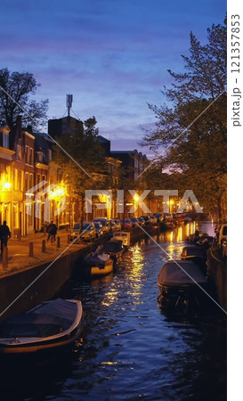 Canal with boats and houses illuminated in the evening. Haarlem, Netherlands 121357853