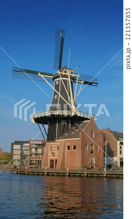 View of Harlem landmark windmill De Adriaan on Spaarne river. Harlem, Netherlands 121357855