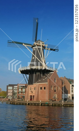 View of Harlem landmark windmill De Adriaan on Spaarne river. Harlem, Netherlands 121357856