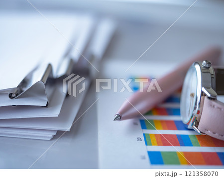 テーブルに置かれたグラフと書類と腕時計 121358070