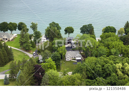 Aerial view of spacious family houses on lake Ontario shore in upstate New York suburban area. Real estate development in American suburbs Aerial view of spacious family houses on lake Ontario shore in upstate New York suburban area. Real estate development in American suburbs 121358486