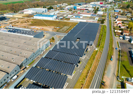 Aerial view of solar panels installed over parking lot with parked cars for effective generation of clean energy Aerial view of solar panels installed over parking lot with parked cars for effective generation of clean energy 121358497