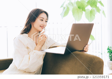 ソファでパソコンを使う女性 121359171