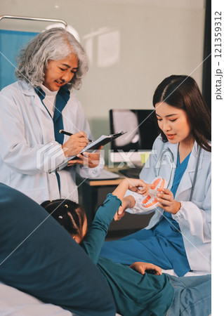 A team of doctors and nurses are working to treat a female patient in the patient's room. A team of doctors and nurses are working to treat a female patient in the patient's room. 121359312