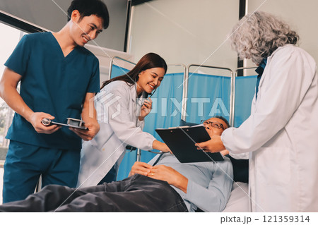 A team of doctors and nurses are working to treat a female patient in the patient's room. 121359314