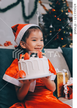 Little girl with Christmas gift at home 121359324