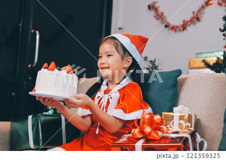 Little girl with Christmas gift at home 121359325