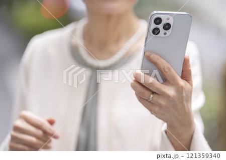 スマートフォンを持ったシニア女性の手元 スマートフォンを持ったシニア女性の手元 121359340