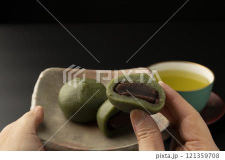 草餅 よもぎ餅 春の味覚 草餅を手で持ち上げる 草餅 よもぎ餅 春の味覚 草餅を手で持ち上げる 121359708