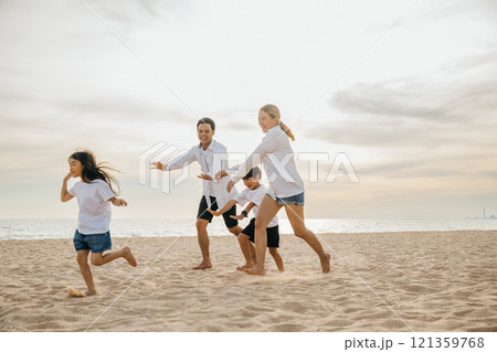 A joyful family on the beach parents and children walking playing and laughing. Summer holiday fun carefree moments and quality family time with smiles and happiness. Family on beach vacation A joyful family on the beach parents and children walking playing and laughing. Summer holiday fun carefree moments and quality family time with smiles and happiness. Family on beach vacation 121359768