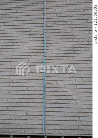 シーリングが劣化して剥がれ落ちていった家の外壁 121359805