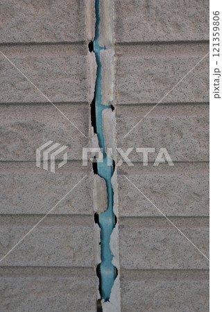 シーリングが劣化して剥がれ落ちていった家の外壁 シーリングが劣化して剥がれ落ちていった家の外壁 121359806