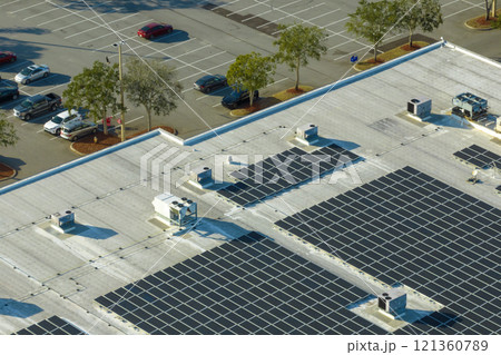 Aerial view of many photovoltaic panels installed on shopping mall roof top for producing of green ecological electricity. Production of sustainable energy concept 121360789