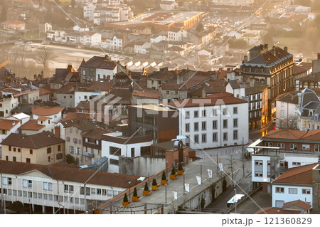 Aerial view of dense historic center of Thiers town in Puy-de-Dome department, Auvergne-Rhone-Alpes region in France. Rooftops of old buildings and narrow streets at sunset 121360829
