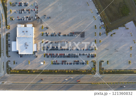 Aerial view of dealership parking lot with many brand new cars for sale near wide american highway. Development of US automotive industry concept Aerial view of dealership parking lot with many brand new cars for sale near wide american highway. Development of US automotive industry concept 121360832