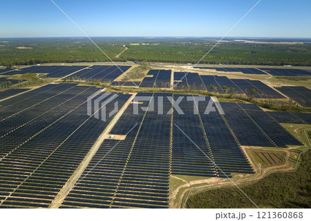 Aerial view of big sustainable electric power plant with many rows of solar photovoltaic panels for producing clean electrical energy. Renewable electricity with zero emission concept 121360868