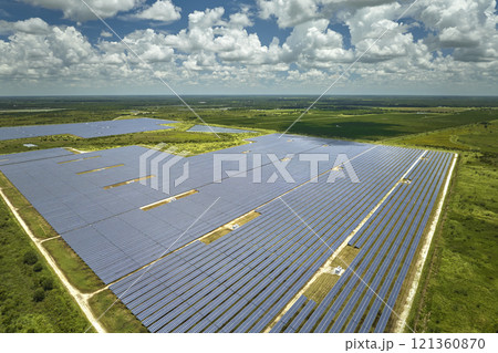 Aerial view of big sustainable electric power plant with many rows of solar photovoltaic panels for producing clean electrical energy. Renewable electricity with zero emission concept Aerial view of big sustainable electric power plant with many rows of solar photovoltaic panels for producing clean electrical energy. Renewable electricity with zero emission concept 121360870
