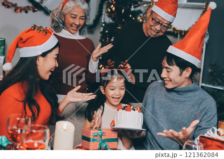 Multi-Generation Family Celebrate Christmas At Home Wearing Santa Hats And Antlers Opening Presents Multi-Generation Family Celebrate Christmas At Home Wearing Santa Hats And Antlers Opening Presents 121362084
