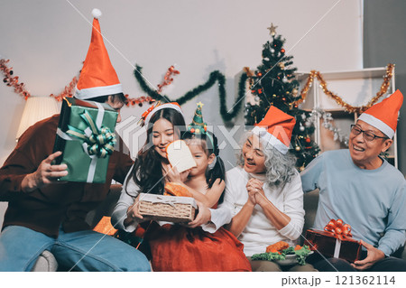 Portrait of Asian family exchanging presents during christmas at home. Attractive happy people holding gift box, celebrate holiday thanksgiving, xmas eve tradition in living room in house together. Portrait of Asian family exchanging presents during christmas at home. Attractive happy people holding gift box, celebrate holiday thanksgiving, xmas eve tradition in living room in house together. 121362114