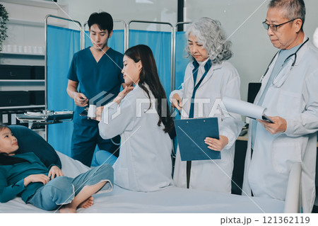 A team of doctors and nurses are working to treat a female patient in the patient's room. A team of doctors and nurses are working to treat a female patient in the patient's room. 121362119