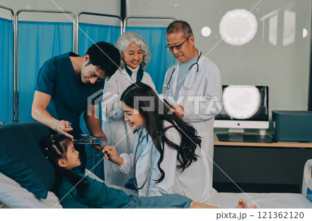 A team of doctors and nurses are working to treat a female patient in the patient's room. A team of doctors and nurses are working to treat a female patient in the patient's room. 121362120