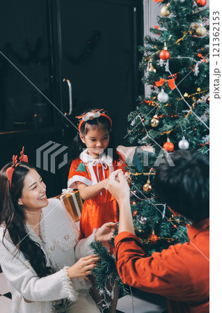 Father, mother and child celebrating Christmas. 121362153