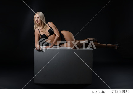 Model posing elegantly on a pedestal in a minimalist studio environment 121363920