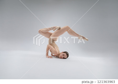 Ballerina performing an impressive dance pose on a neutral background 121363963