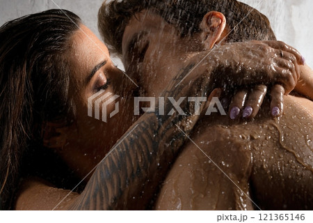 Naked couple embracing and kissing in shower 121365146