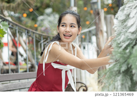 Portrait of young asian beautiful woman happy smiling with snow on Christmas Day with braces. Happy girl in good mood smile showing teeth. 121365469