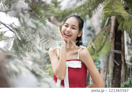 Portrait of young asian beautiful woman happy smiling with snow on Christmas Day with braces. Happy girl in good mood smile showing teeth. 121365567