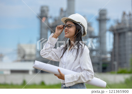 Engineer with blueprint working factory producing electricity oil energy. Construction manager oil refinery in petrochemical. improvement inspector Industrial worker working power plant 121365900