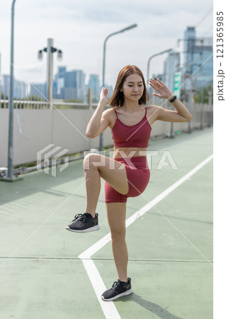 Young beautiful woman sportswear workout clothes exercise in street city park before morning run. Asian strong female sporty sportswear stretching outdoors. fitness healthy concept. 121365985
