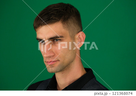 emotions of a handsome man guy on a green background chromakey close-up dark hair young man 121368074