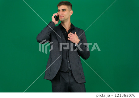 An Indian man looks tense and frustrated while talking on his mobile phone in a modern office setting, showing signs of anger and stress. An Indian man looks tense and frustrated while talking on his mobile phone in a modern office setting, showing signs of anger and stress. 121368076