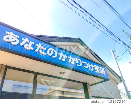 青い空とかかりつけ薬局の看板 121372144