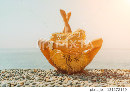Beach Relaxation woman lies on a pebble beach, legs raised, and arms spread out. The concept of travel, vacation at sea 121372159