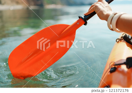Kayak paddle sea vacation. Person paddles with orange paddle oar on kayak in sea. Leisure active lifestyle recreation activity rest tourism travel 121372176