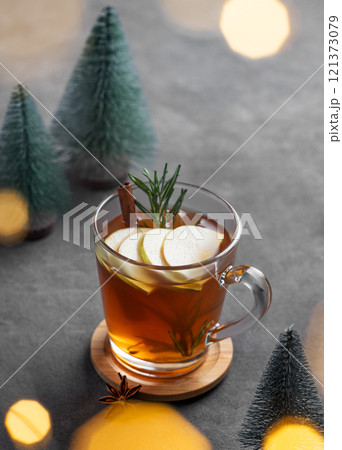 Homemade apple punch with fresh apples, cinnamon and rosemary in a cup on a dark background 121373079