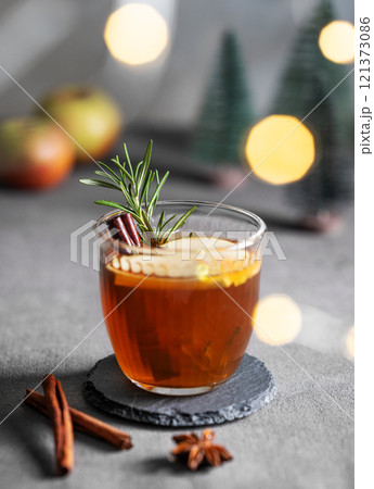 Homemade apple punch with fresh apples, cinnamon and rosemary in a cup on a dark background Homemade apple punch with fresh apples, cinnamon and rosemary in a cup on a dark background 121373086