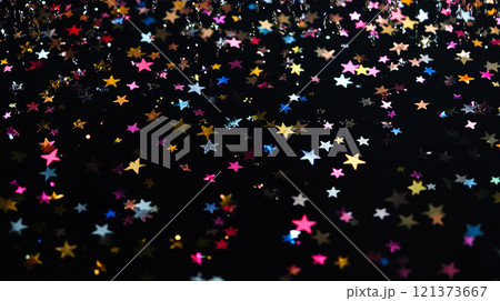 Colorful star confetti falling against a dark background during a celebration. Generative AI 121373667