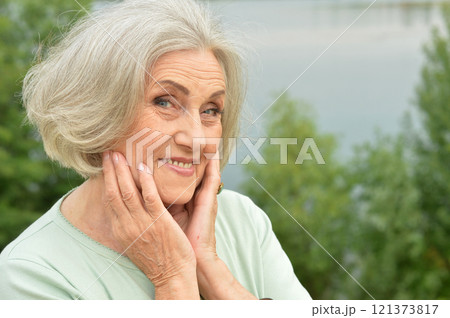 Portrait of a beautiful elderly woman in the park 121373817